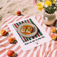 Bacalao al Pil Pil – on Striped Tablecloth, Spanish Food Wall Decor, unframed on coastal sand